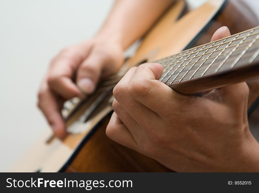 Man strumming and playing the guitar