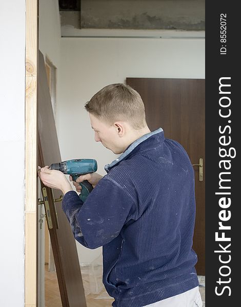 construction joiner installs door. insertion screw