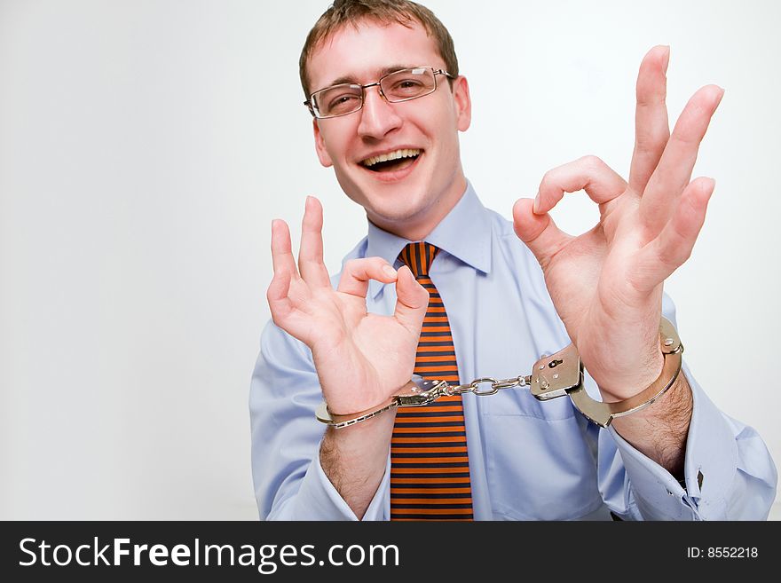 Handsome young businessman bound to laptop with handcuffs. Handsome young businessman bound to laptop with handcuffs