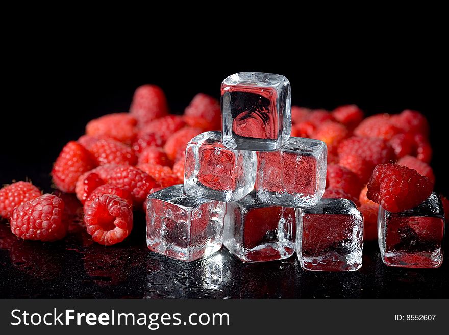 Ice cubes and raspberries islated on black. Ice cubes and raspberries islated on black