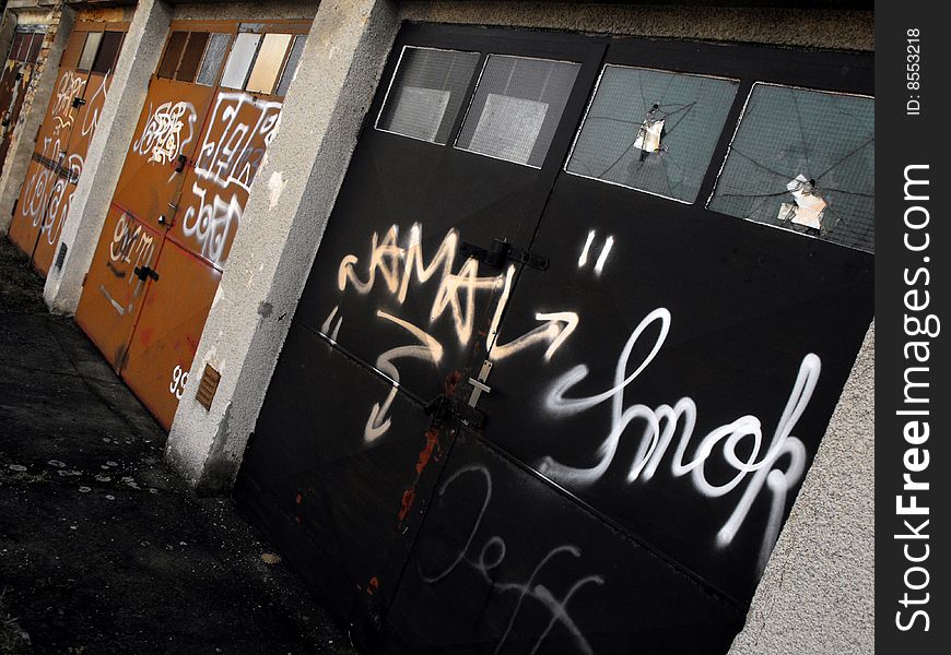 Angled shot of garage doors vandalized and marred with graffiti. Taken in Prague. Angled shot of garage doors vandalized and marred with graffiti. Taken in Prague.