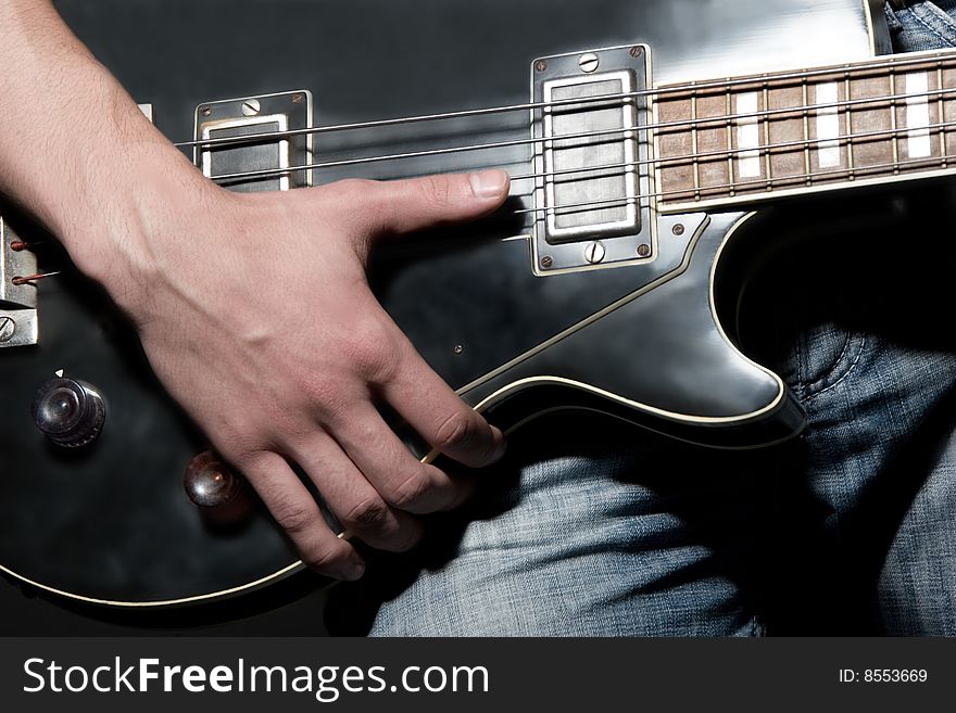 Musician playing in vintage bass guitar.