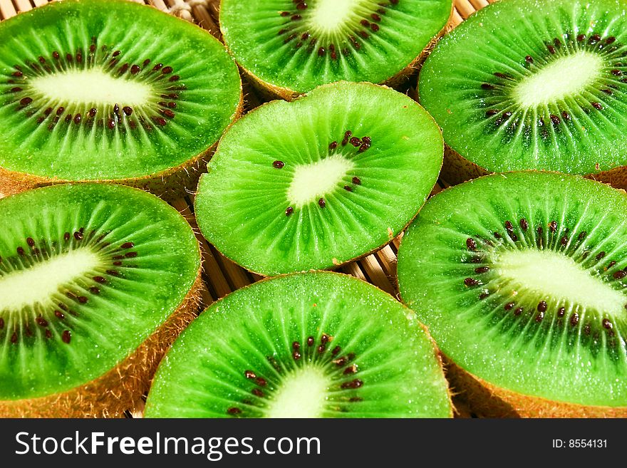 Close-up of fresh kiwi slices on a bamboo mat. Close-up of fresh kiwi slices on a bamboo mat