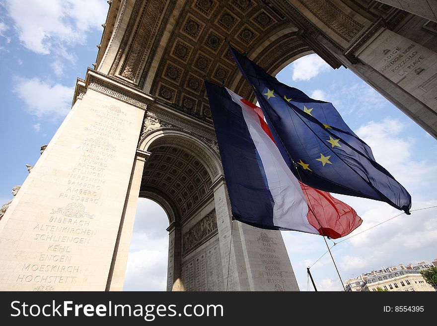 The flags of France and the European Union flying under the Arc de Triomphe in Paris, France. The flags of France and the European Union flying under the Arc de Triomphe in Paris, France.