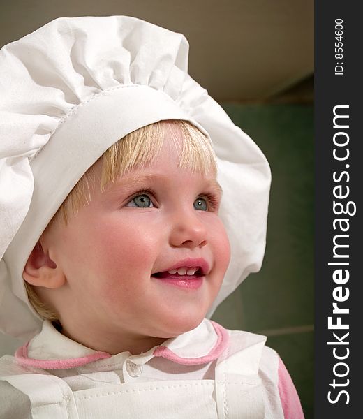 Girl in hubcap smiles on kitchen