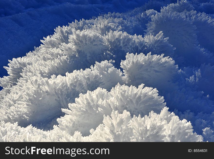 Fine ice crystals on snow mounds formed by hoar frost