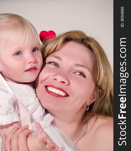 Beauty woman embraces blond daughter. Beauty woman embraces blond daughter