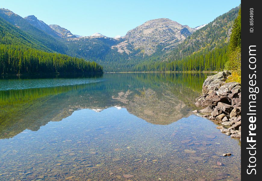A mountain reflection in a wilderness lake in Montan. A mountain reflection in a wilderness lake in Montan
