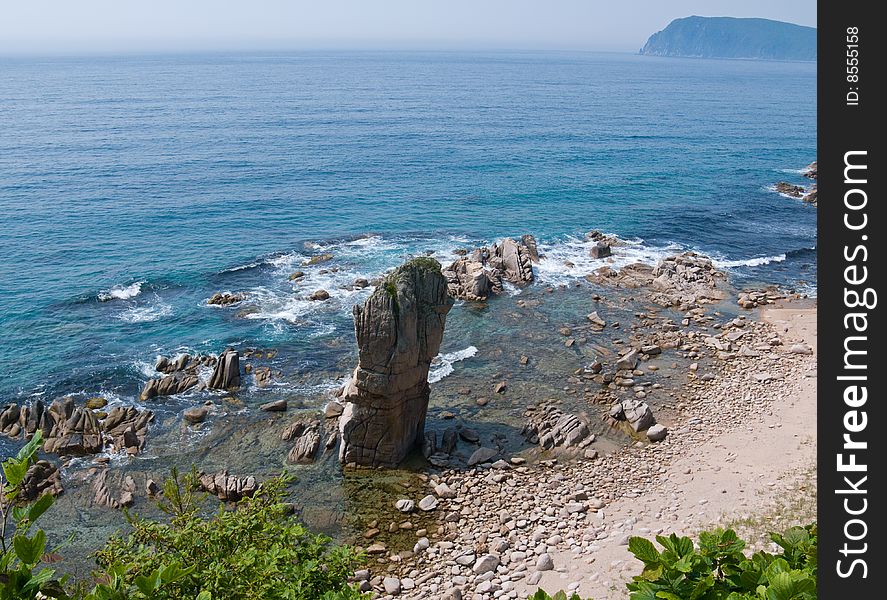 A small bay with alone tall rock. Japanese sea. A small bay with alone tall rock. Japanese sea.