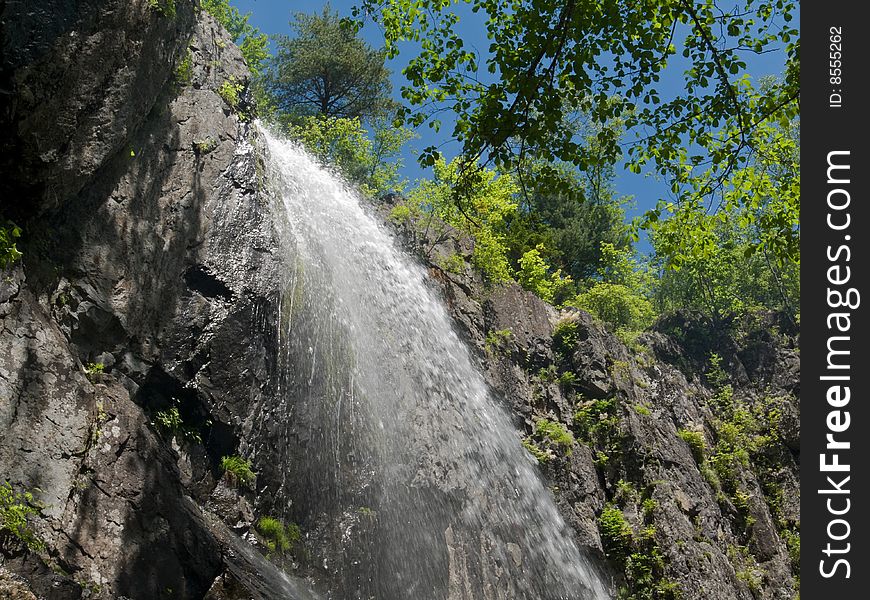 A waterfall among taiga. Russian Far East, waterfall Elamovsky. A waterfall among taiga. Russian Far East, waterfall Elamovsky.