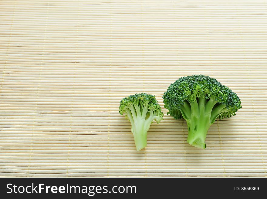 Two broccolli on wooden background, close up. Two broccolli on wooden background, close up