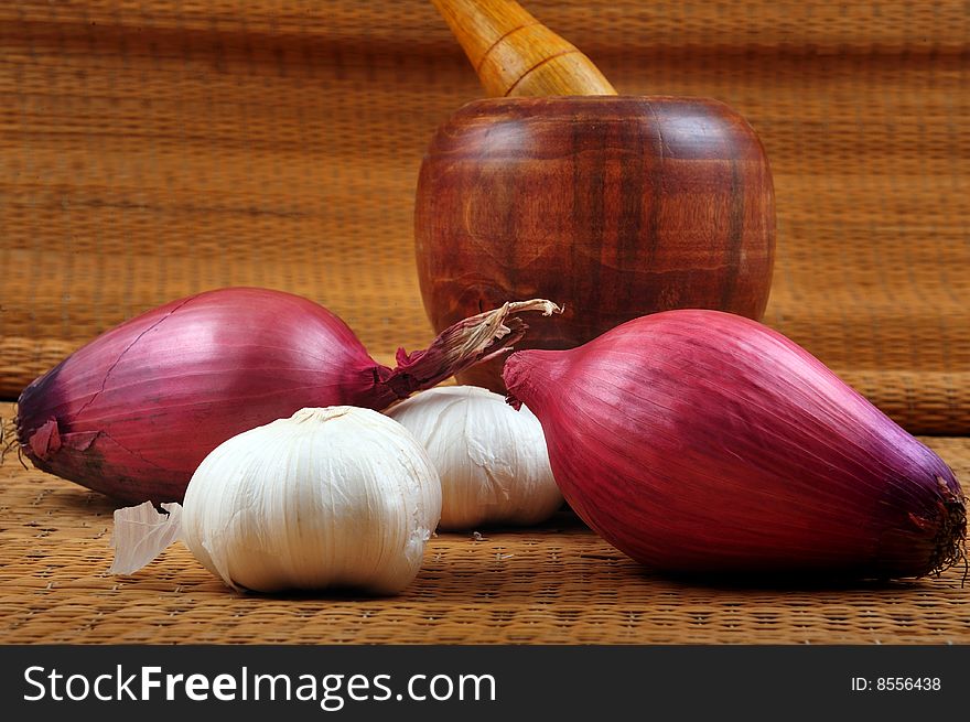 Garlic, onion and pestle on wooden background. Garlic, onion and pestle on wooden background