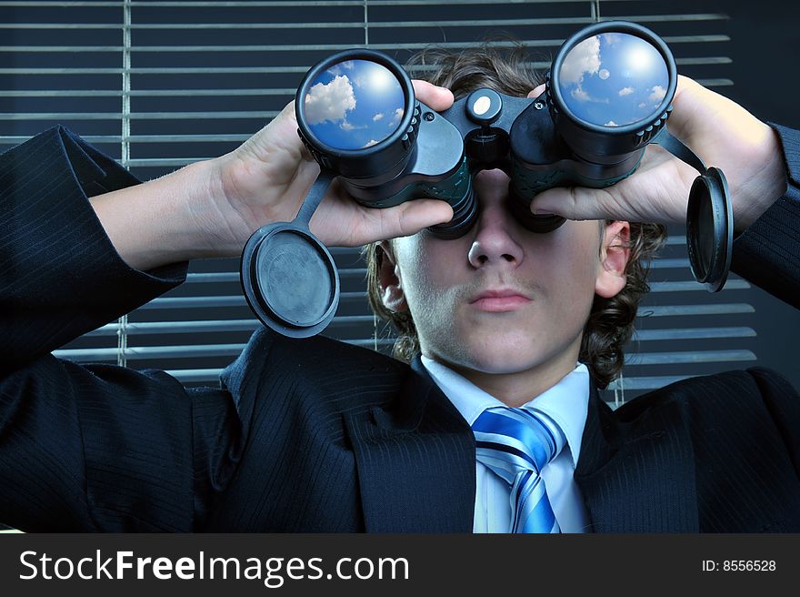 Businessman looking through binoculars, sky reflection on lens. Businessman looking through binoculars, sky reflection on lens