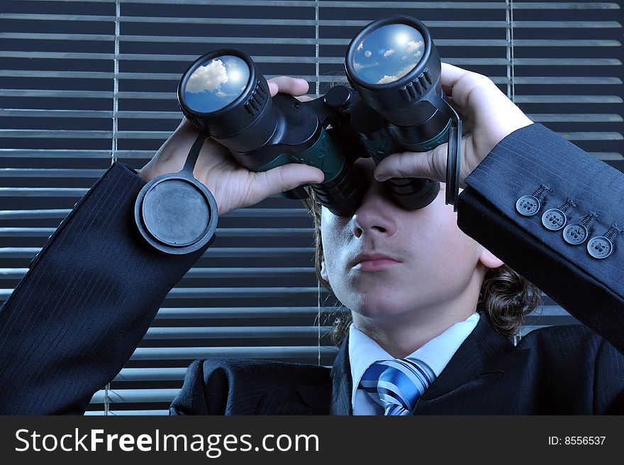 Businessman looking through binoculars, sky reflection on lens. Businessman looking through binoculars, sky reflection on lens