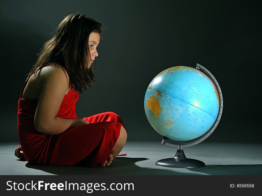 Girl in red dress standing in front of Earth globe. Girl in red dress standing in front of Earth globe
