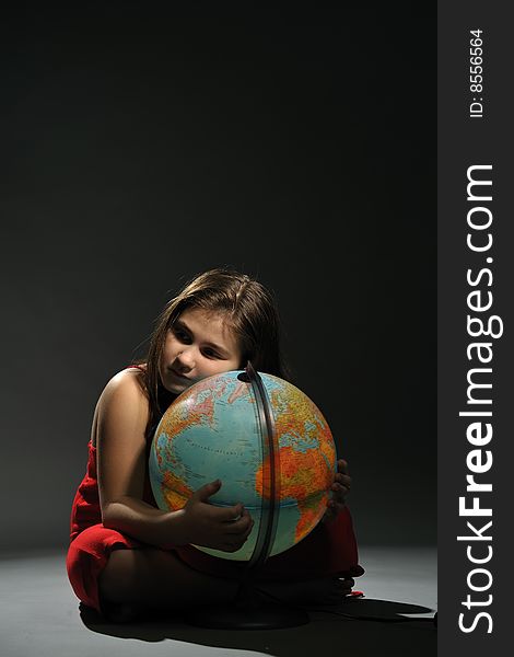 Little girl in red dress embracing Earth globe. Little girl in red dress embracing Earth globe