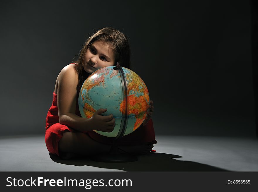 Little girl in red dress embracing Earth globe. Little girl in red dress embracing Earth globe