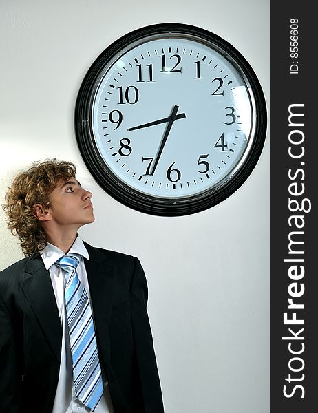 Young businessman looking at clock, deadline concept. Young businessman looking at clock, deadline concept