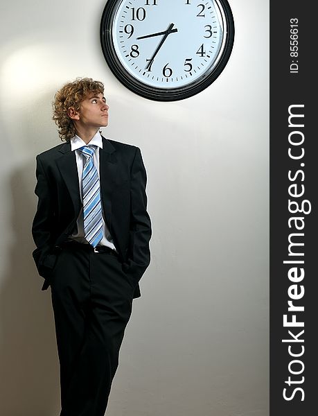 Young businessman looking at clock, deadline concept. Young businessman looking at clock, deadline concept