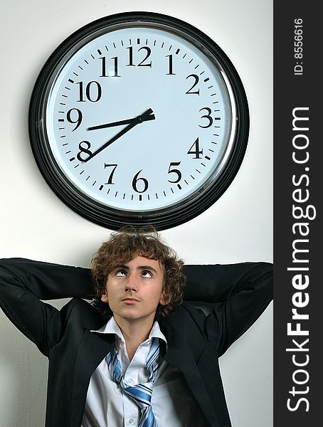 Young businessman looking at clock, deadline concept. Young businessman looking at clock, deadline concept