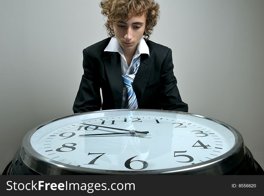 Young businessman looking at clock, deadline concept