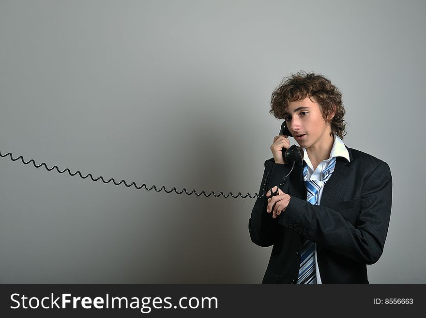 Young business man talking on old phone. Young business man talking on old phone
