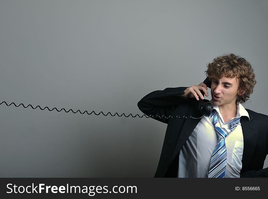 Young business man talking on old phone. Young business man talking on old phone