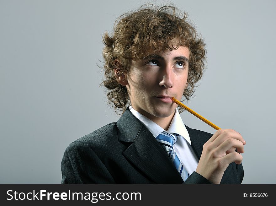 Young businessman holding a pencil in his mouth. Young businessman holding a pencil in his mouth