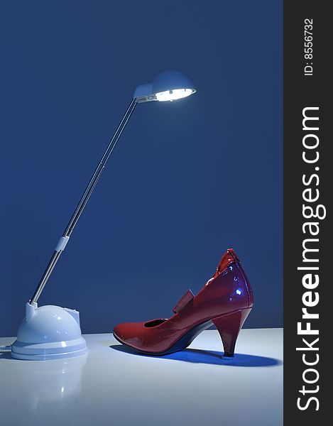 Women high heel shoe under a reading lamp light