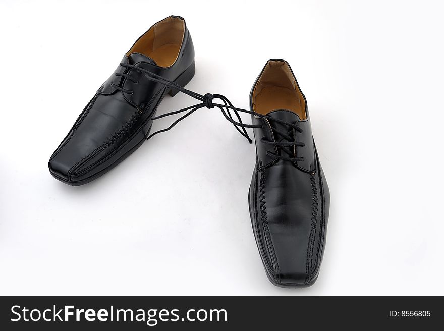 Pair of black man shoes tied together on white background. Pair of black man shoes tied together on white background