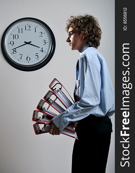 Young businessman holding stack of folders in office, deadline concept. Young businessman holding stack of folders in office, deadline concept