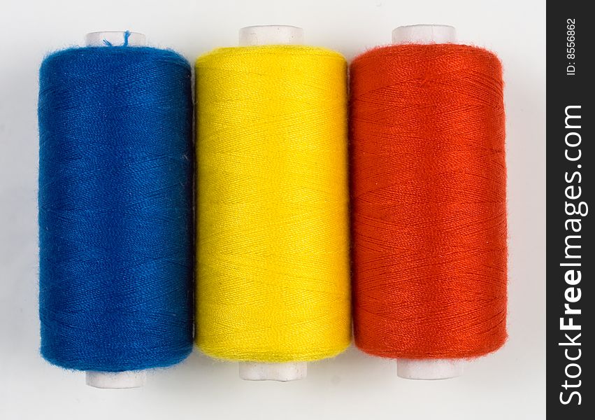 Close up of three colored sewing spools