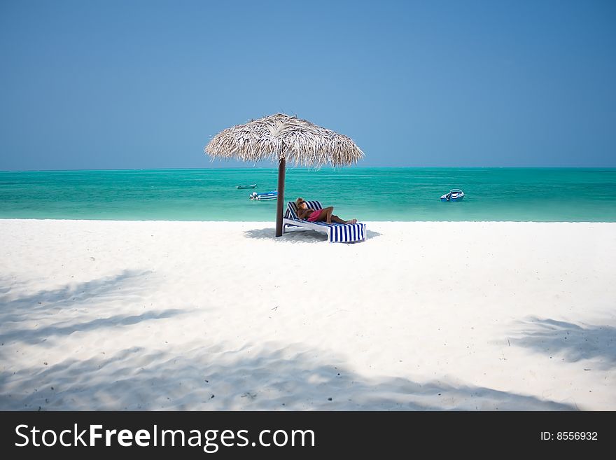 Beautiful woman lying on bed at tropical beach