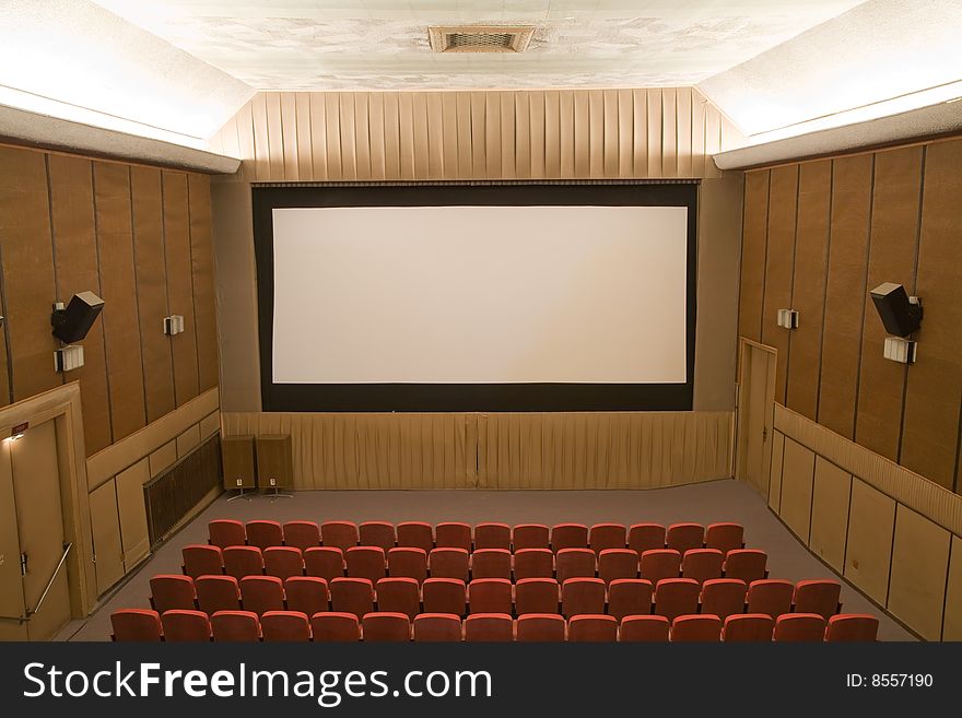Old retro style cinema auditorium with line of red chairs and silver screen. Ready for adding your own picture. Old retro style cinema auditorium with line of red chairs and silver screen. Ready for adding your own picture.