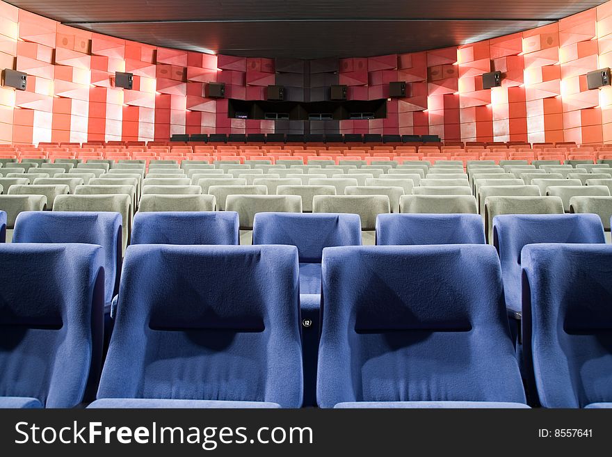 Empty new cinema auditorium with rows of blue, gray and red chairs. Empty new cinema auditorium with rows of blue, gray and red chairs.