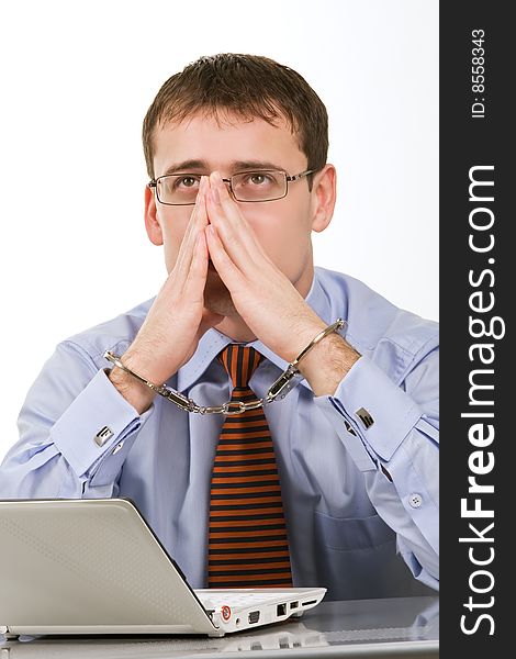 Handsome young businessman bound to laptop with handcuffs. Handsome young businessman bound to laptop with handcuffs