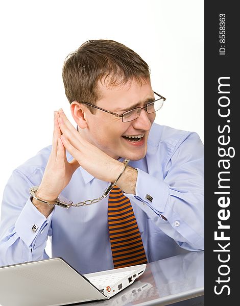 Handsome young businessman bound to laptop with handcuffs. Handsome young businessman bound to laptop with handcuffs