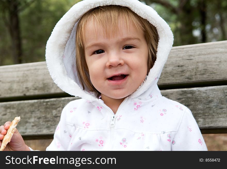 A young girl having a tea-break on a bench in a public park. A young girl having a tea-break on a bench in a public park