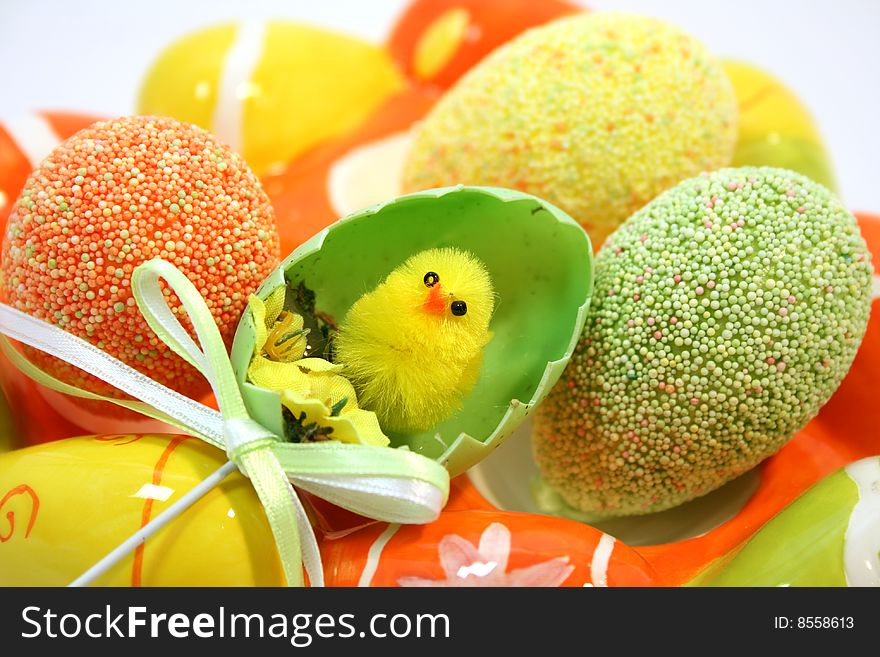 Yellow toy easter chick hatching out of an egg shell