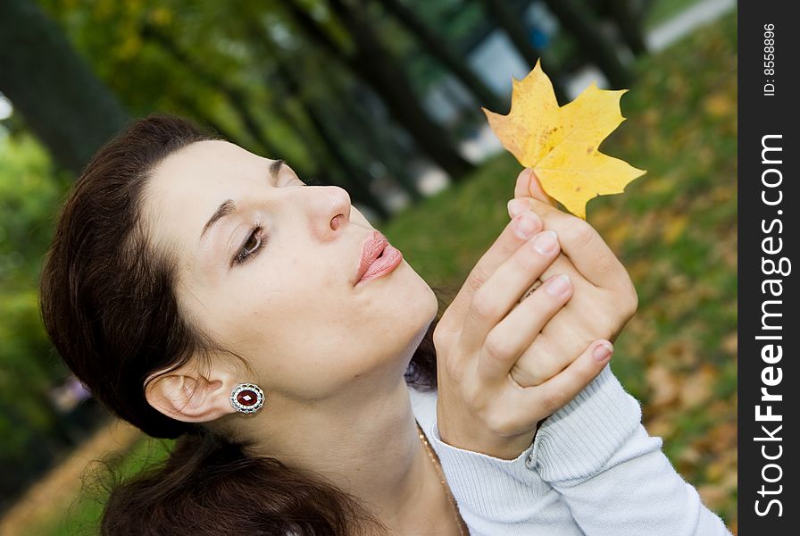 Pretty girl blowing on leaf