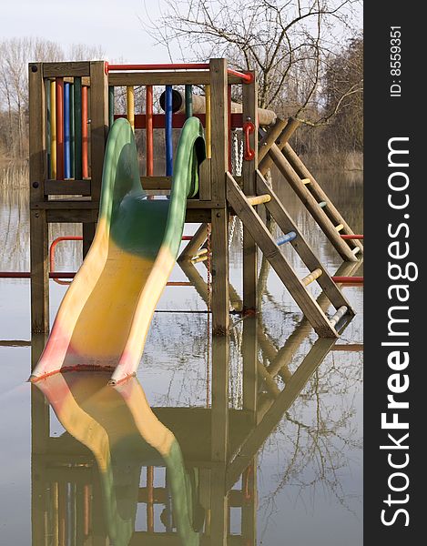 Playground under water, child slide is mirrored in the water