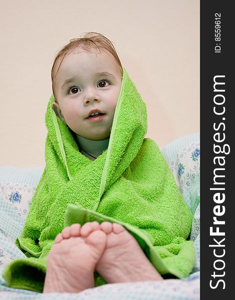Bath a baby, boy wrapped in green towel