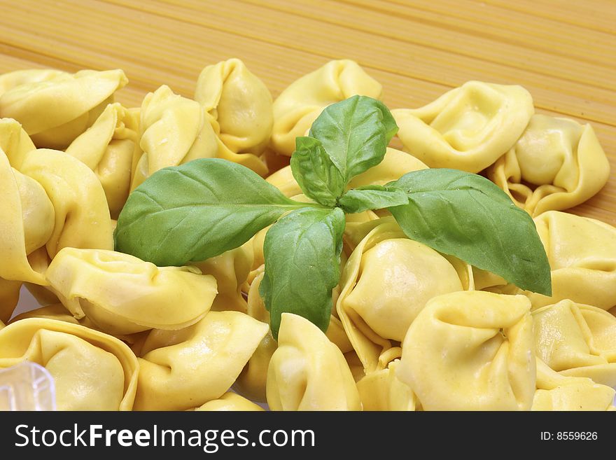 Raw spaghetti and tortellini with basil. Raw spaghetti and tortellini with basil