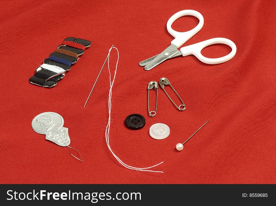 Different sewing utensils over red background. Different sewing utensils over red background