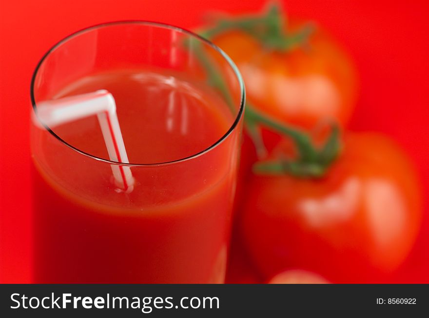 Fresh tomato juice and ripe tomatoes on a red background. Fresh tomato juice and ripe tomatoes on a red background