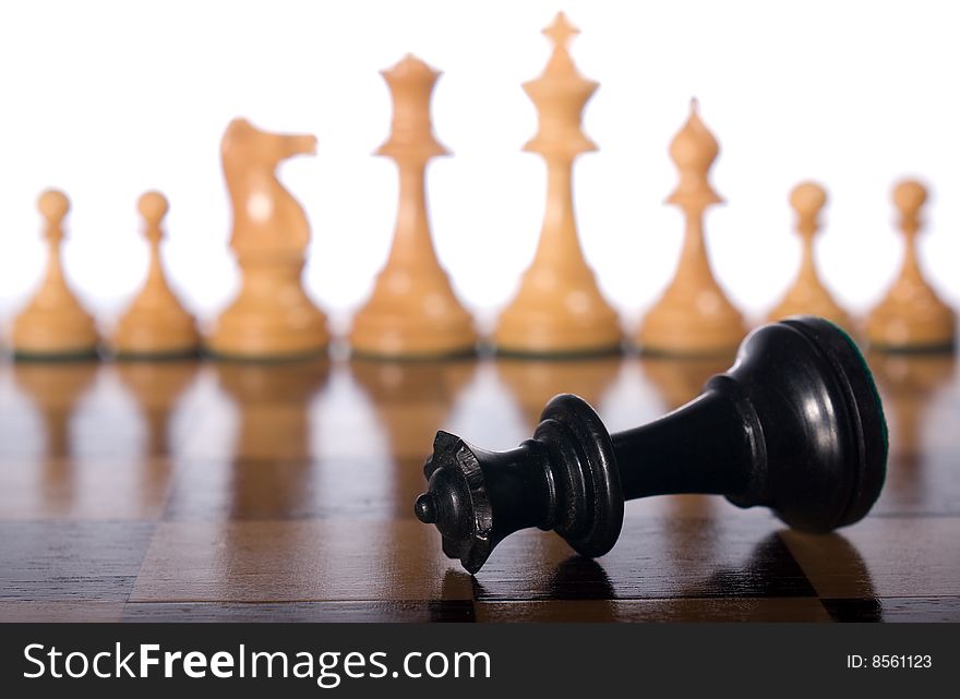 Chess queen on a chessboard as a business concept with out of focus chessmen. Chess queen on a chessboard as a business concept with out of focus chessmen