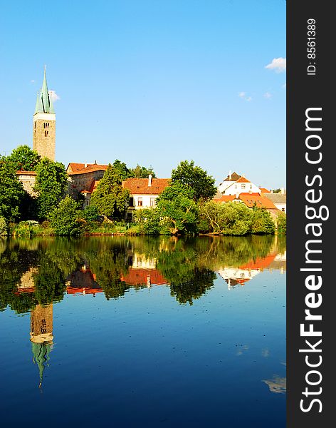 Tower and Houses reflected in the lake surrounding the city of Telc, Southern Moravia, Czech Republic. Tower and Houses reflected in the lake surrounding the city of Telc, Southern Moravia, Czech Republic.