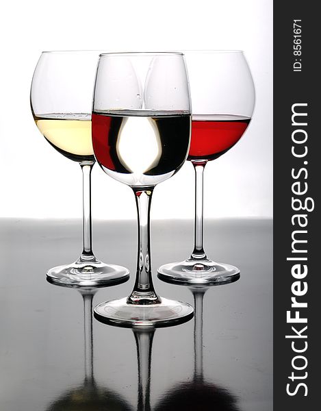 Three glasses of wine (white yellow and red) with reflections and optical effects