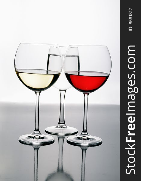 Three glasses of wine (white yellow and red) with reflections and optical effects