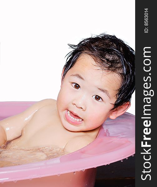 A picture of a little chinese boy taking bath and playing with water happily. A picture of a little chinese boy taking bath and playing with water happily
